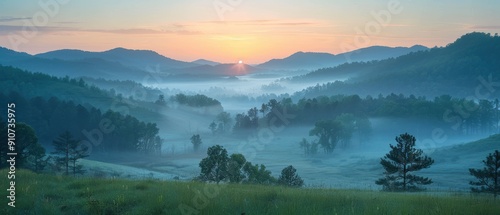 Tranquil Sunrise over Misty Valley with Layers of Mountains and Trees