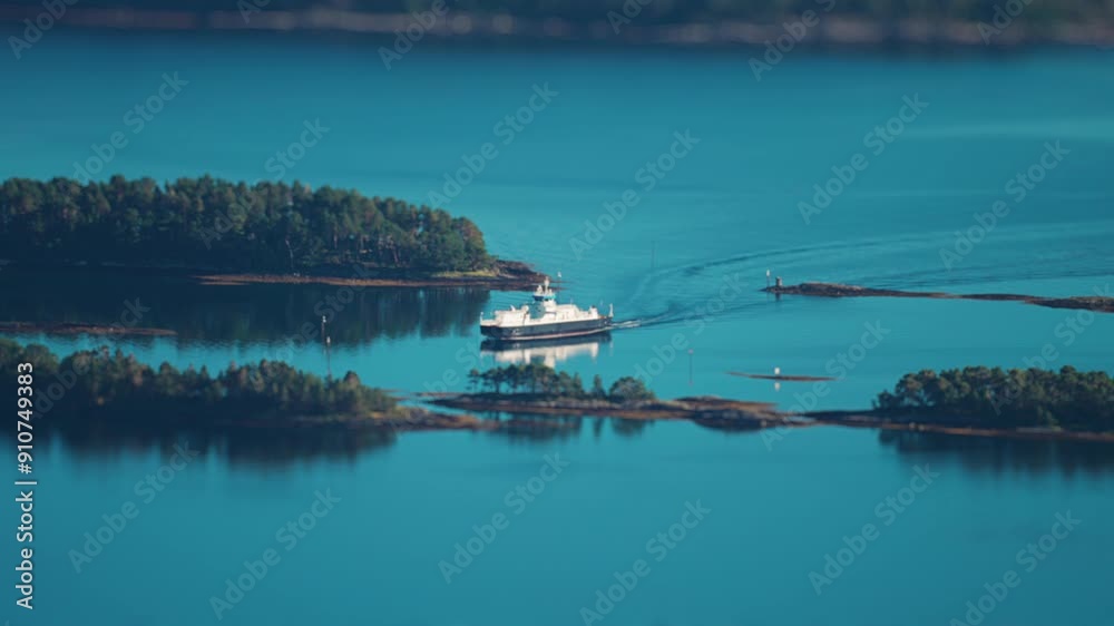 A ferry maneuvers between islets on its' way to the Molde port. The town is in the foreground. Tilt-shift video. A ferry maneuvers between islets on its' way to the Molde port. The town is in the foreground. Tilt-shift video.