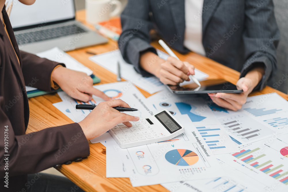 Two colleagues review financial documents with charts and graphs during a business meeting, focusing on analysis and decision-making. Two colleagues review financial documents with charts and graphs during a business meeting, focusing on analysis and decision-making.