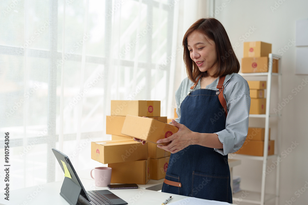 Business entrepreneur or independent Asian woman using laptop with parcel box successful I'm happy and proud of my success in my startup business. Packaging boxes, marketing and online shipping. Business entrepreneur or independent Asian woman using laptop with parcel box successful I'm happy and proud of my success in my startup business. Packaging boxes, marketing and online shipping.