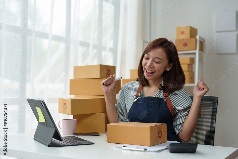Business entrepreneur or independent Asian woman using laptop with parcel box successful I'm happy and proud of my success in my startup business. Packaging boxes, marketing and online shipping. Business entrepreneur or independent Asian woman using laptop with parcel box successful I'm happy and proud of my success in my startup business. Packaging boxes, marketing and online shipping.