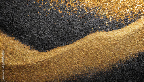 Glittering gold dust and shiny golden sand stripes poured on black rough rock wall or surface with small granulated dark stones luxurious abstract grainy texture, wallpaper or background.