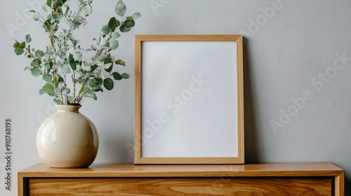 Wooden Frame and Vase with Greenery on a Wooden Dresser