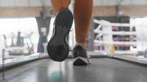 Close up of female feet of a young Asian woman walking and jogging on treadmill to warm up before starting her morning exercise