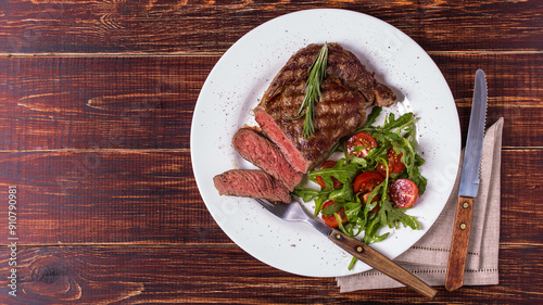 Ribeye steak with arugula and tomatoes. photo