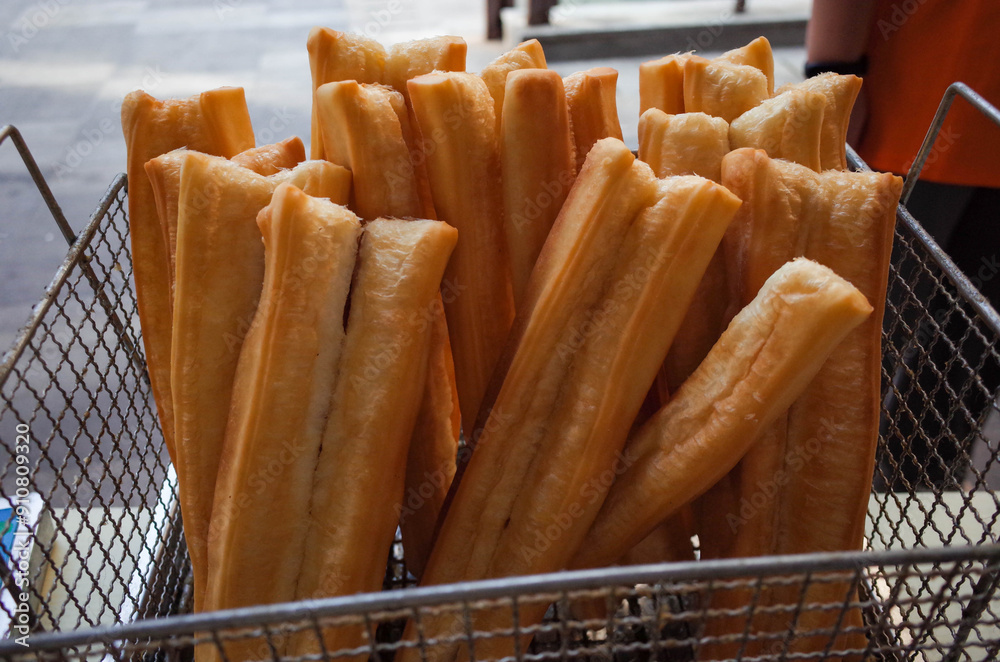Deep-fried dough stick for sale in food market. Fried bread stick.