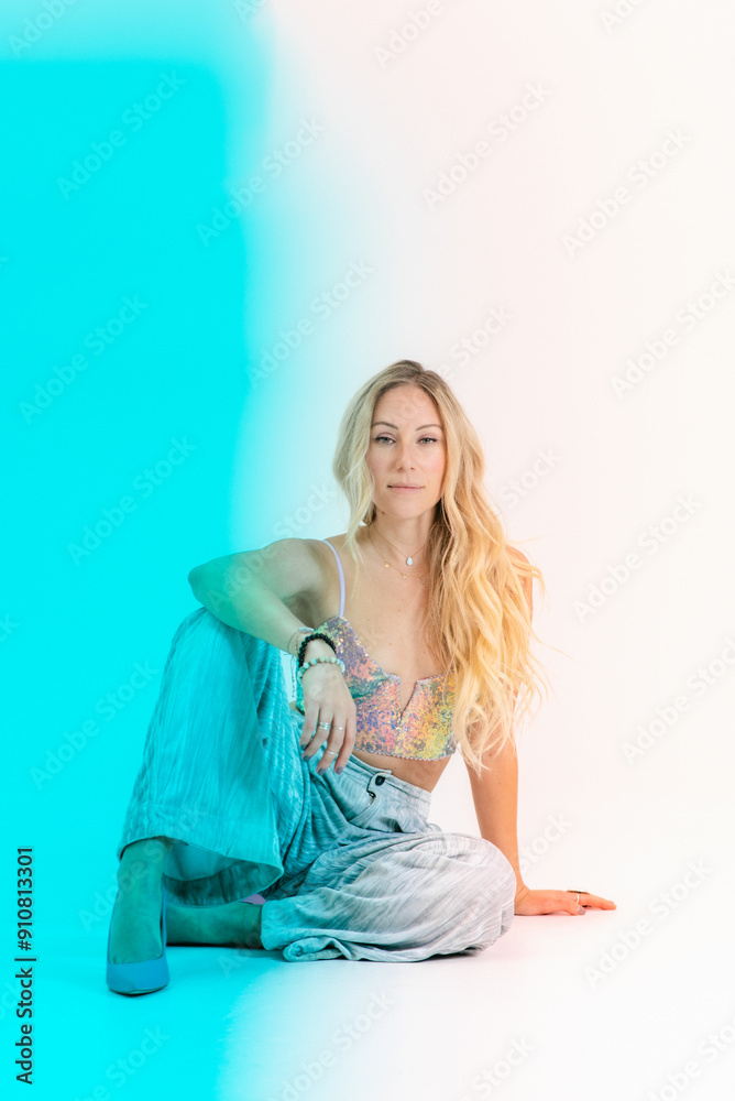 Blonde woman sitting confidently with colorful blue lighting eff Blonde woman sitting confidently with colorful blue lighting eff