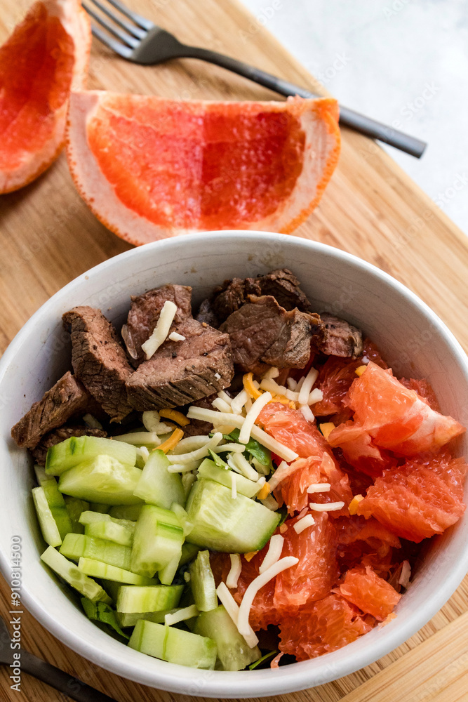 Bowl of citrus salad with grapefruit, steak, cucumbers, and cheese. Bowl of citrus salad with grapefruit, steak, cucumbers, and cheese.