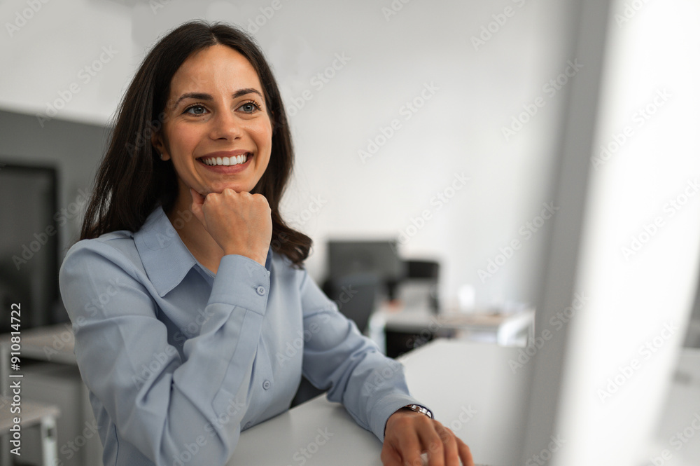 Young smiling employee reading on a computer screen Young smiling employee reading on a computer screen