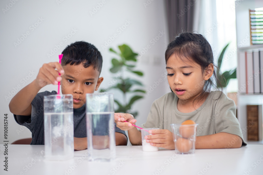 Two children are playing with a science experiment involving water and eggs Two children are playing with a science experiment involving water and eggs