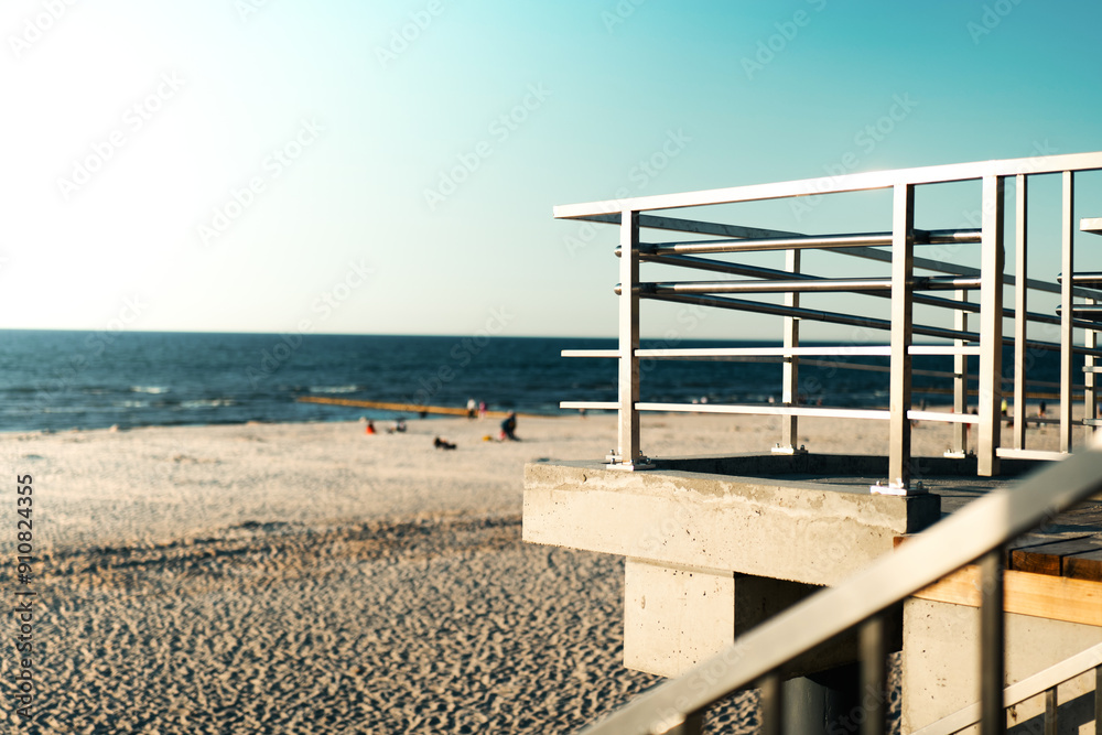 Viewing platform with a protective barrier. View of the sea and sandy beach. Stainless steel balustrade