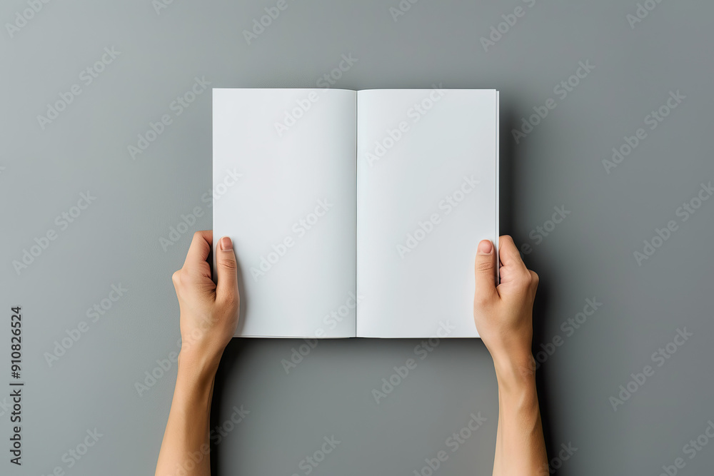 A person is holding an open book with a blank page. A person is holding an open book with a blank page.