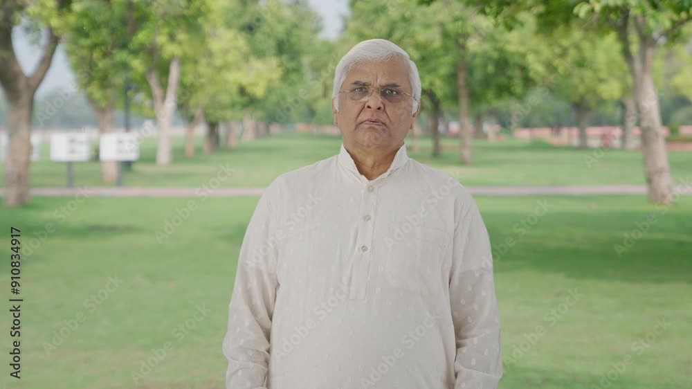 Sad Indian old man watching something tragic in park