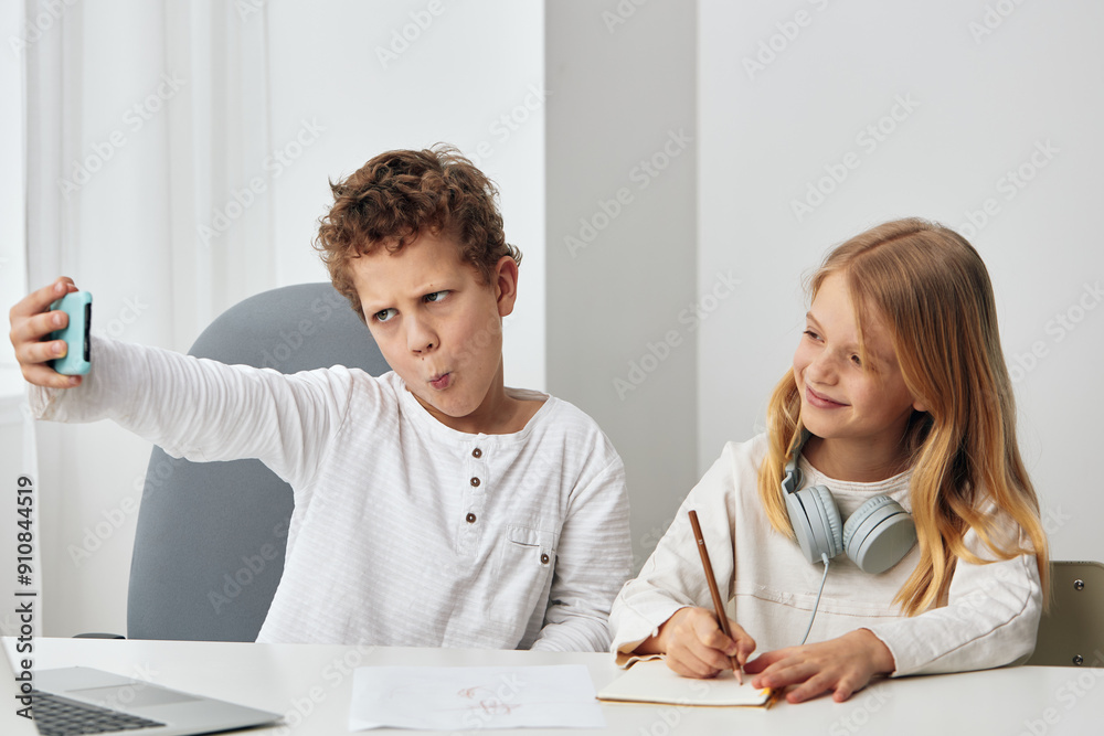 Happy Boy and Girl Taking a Selfie with Their Smartphones, Capturing a Moment of Sibling Bonding and Online Friendship Happy Boy and Girl Taking a Selfie with Their Smartphones, Capturing a Moment of Sibling Bonding and Online Friendship
