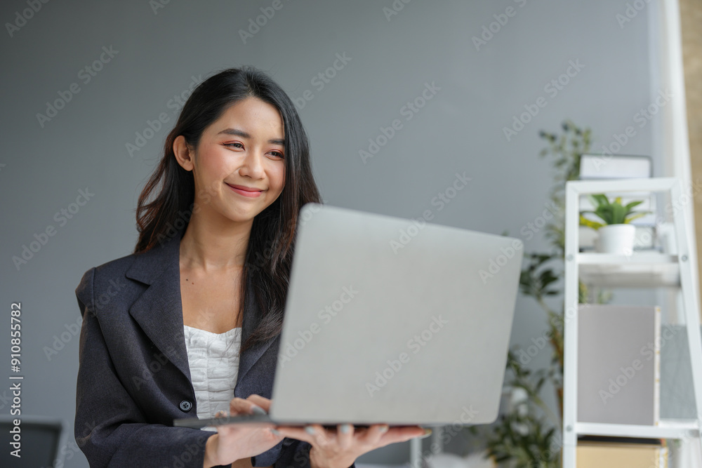Asian business woman happily recording data on laptop Details from the graph Business income charts in real estate, taxes, management, technology marketing online in the office. Asian business woman happily recording data on laptop Details from the graph Business income charts in real estate, taxes, management, technology marketing online in the office.