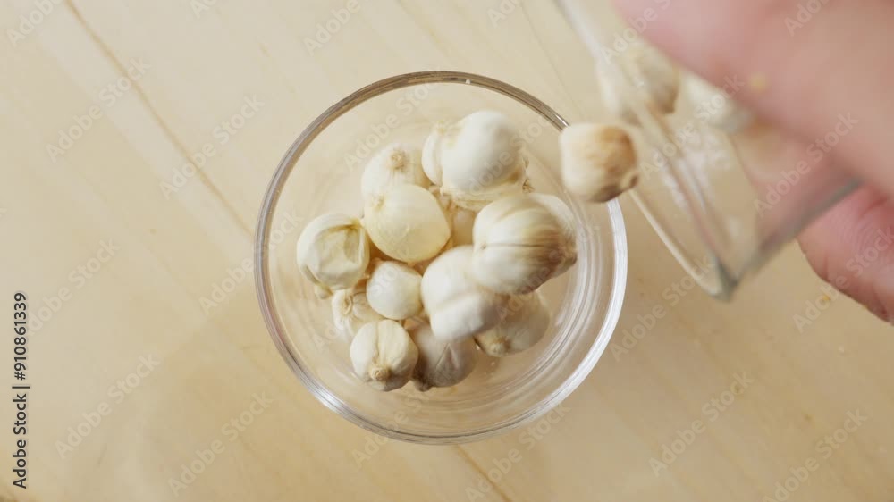 Cardamom seeds being poured into a glass bowl in slow motion, top view Cardamom seeds being poured into a glass bowl in slow motion, top view