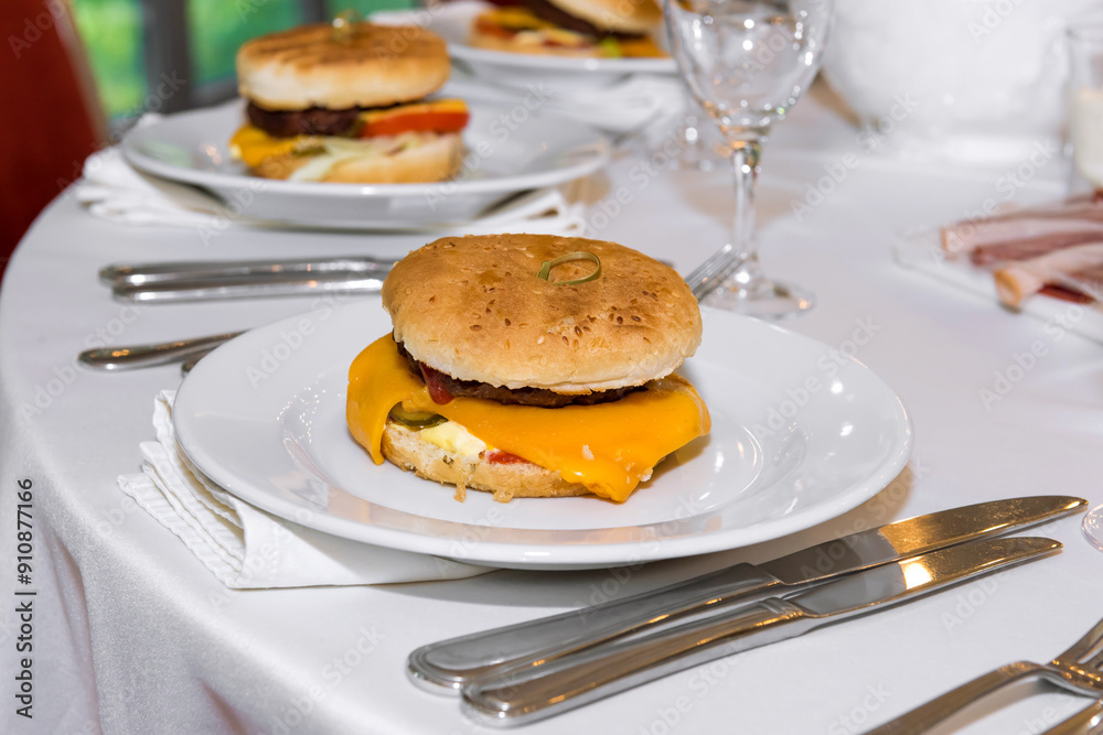 A popular American burger with minced beef, lettuce leaves, tomatoes, cheese, served in a soft bun. Freshly baked sandwich sprinkled with sesame seeds. delicious burger, burger menu, fast food. A popular American burger with minced beef, lettuce leaves, tomatoes, cheese, served in a soft bun. Freshly baked sandwich sprinkled with sesame seeds. delicious burger, burger menu, fast food.