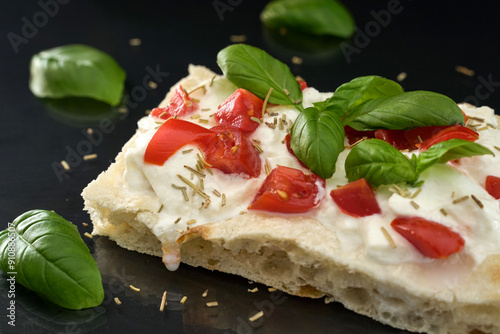 Pizza topped with tomatoes, mozzarella and fresh basil