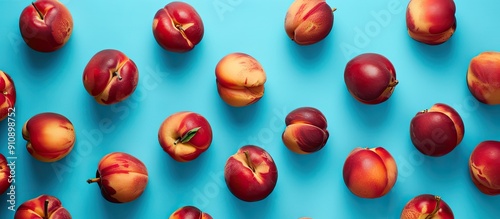 Fresh nectarines arranged in a flat lay on a blue backdrop shot from above with an area for adding text or images. Creative banner. Copyspace image