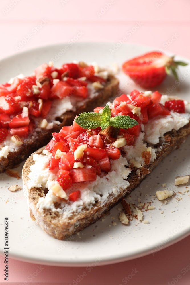 Bruschettas with ricotta cheese, chopped strawberries and mint on pink wooden table, closeup Bruschettas with ricotta cheese, chopped strawberries and mint on pink wooden table, closeup