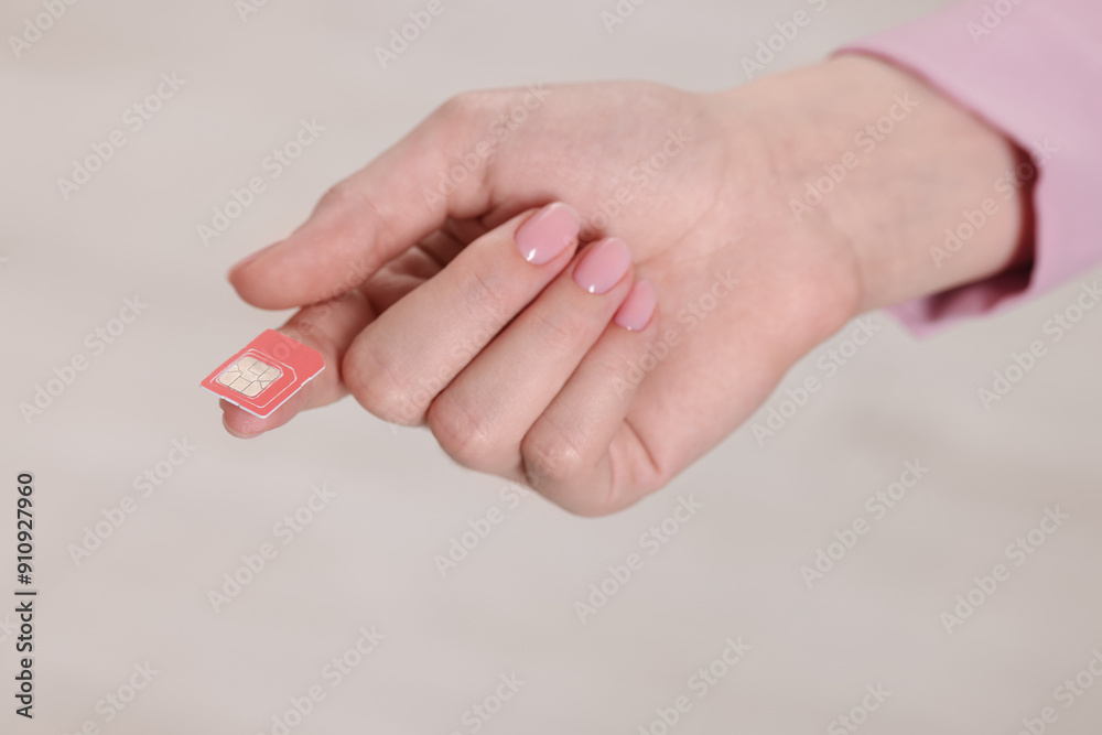 Woman holding SIM card indoors, closeup view Woman holding SIM card indoors, closeup view