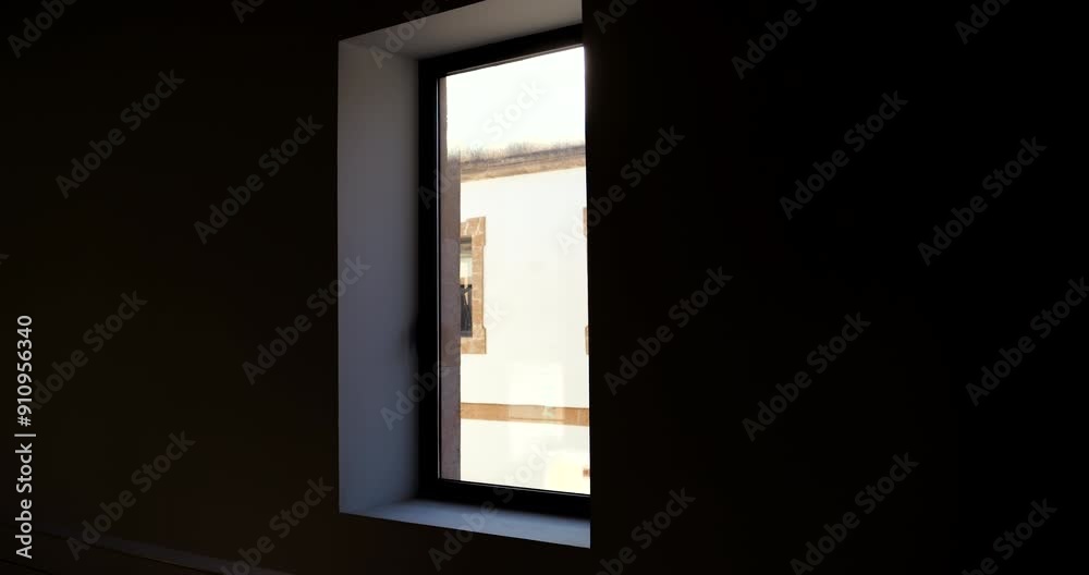 A dark room with a window showing the view of another window, creating a layered and mysterious atmosphere with subtle lighting and depth A dark room with a window showing the view of another window, creating a layered and mysterious atmosphere with subtle lighting and depth