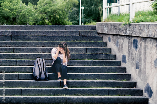 Sad college student at school. Anxiety or stress of youth. Abuse or harassment victim. Unhappy girl. Bullying or discrimination. Lonely outcast crying. Teenage girl in fear. University pressure.