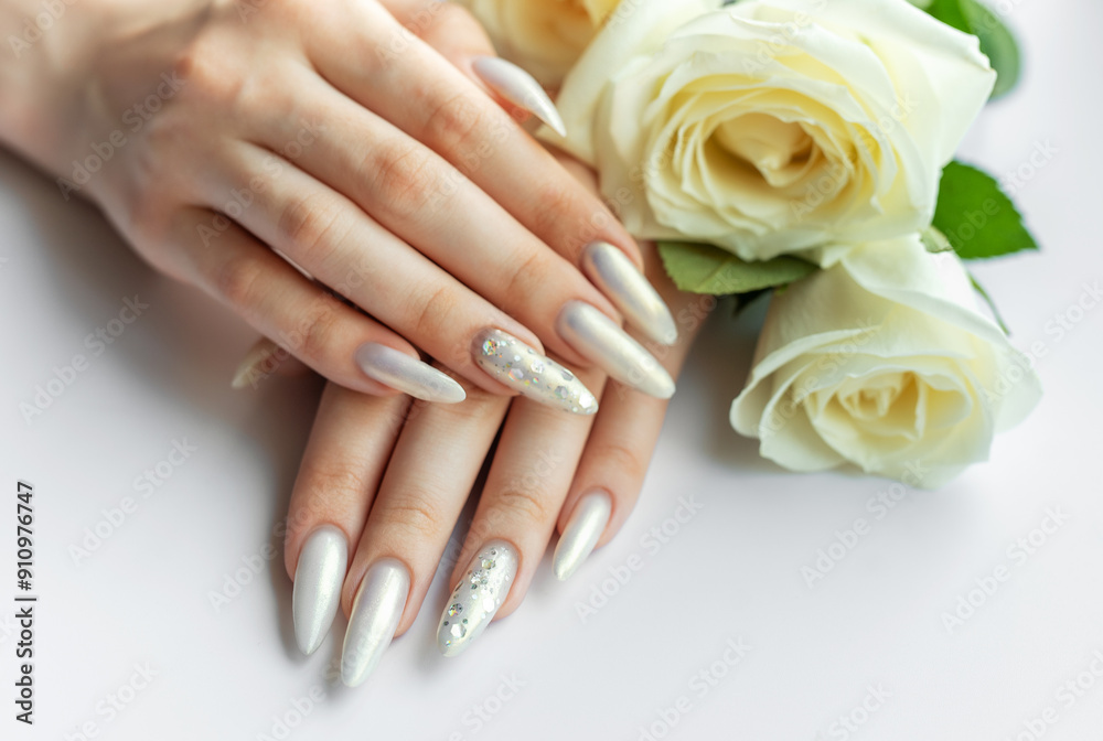 Fototapeta premium Female Hands with beautiful pearl manicure and white roses.