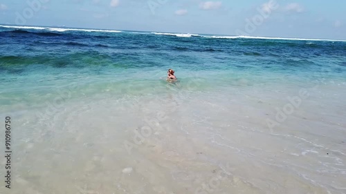Jl. Pantai Sel. Gau Banjar Wijaya Kusuma, Ungasan, Kabupaten Badung, Bali, Indonesia - 08/05/2024: Beach view. Big waves with blue water and golden sand on the beach, blue waves. Girl swimming
