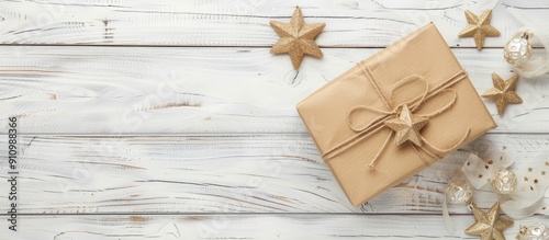 Gift box with star shaped decorations on a white wooden table background with ample copy space image