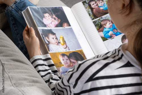 Woman looking at family photo album about her family.