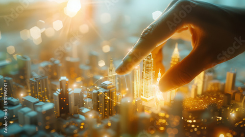 A giant hand carefully places a glowing skyscraper in a miniature cityscape, bathed in golden light. photo