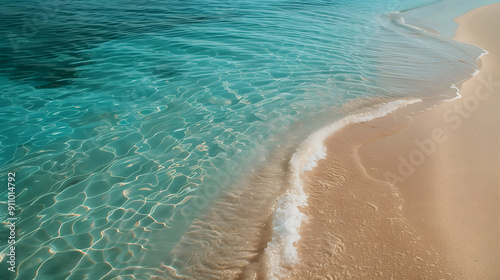 Vertical PHOTOGRAPHY showing a vertical gradient of light sand, on the shore, the water that reaches the shore and soaks the sand, a calm Mediterranean sea and a soft blue diaphane sky