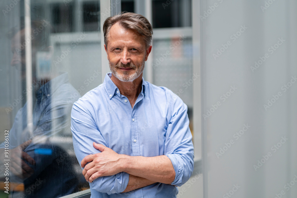 Smiling senior businessman leaning with arms crossed Smiling senior businessman leaning with arms crossed