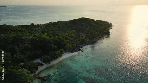 reverse dolly aerial view of Tanjung Gelam or Sunset Beach during sunset time, Karimunjawa, Central Java - Indonesia photo