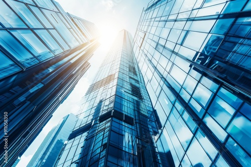 Modern office building with blue sky and glass facade, depicting the concept of economy and finance from a bottom-up view, with a blurred background.