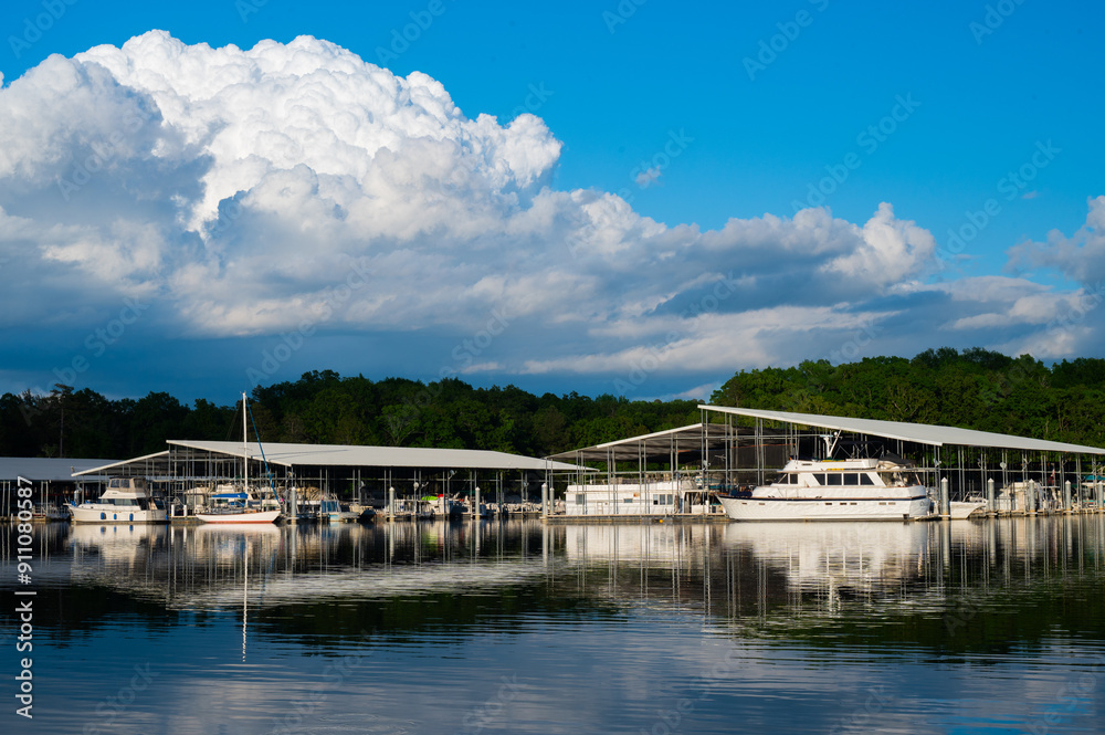 Boats docked at a marina with bright blue sky reflected in the water at Harrison Bay State Park, Tennessee Boats docked at a marina with bright blue sky reflected in the water at Harrison Bay State Park, Tennessee