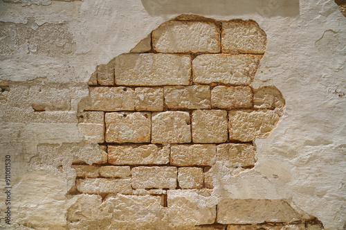 Ruined wall in a street of a city with exposure of bricks