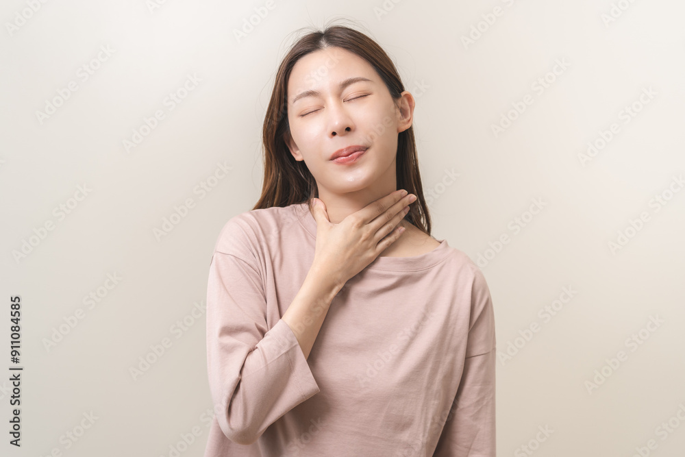 Sickness in inflaming asian young woman, girl use hand check self touch at sore throat, pain thyroid gland on neck or disease reflux, acid of suffer people on wall background. Medical and healthcare. Sickness in inflaming asian young woman, girl use hand check self touch at sore throat, pain thyroid gland on neck or disease reflux, acid of suffer people on wall background. Medical and healthcare.
