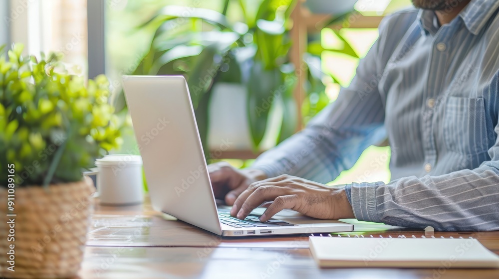 Man Working on Laptop at Home Office Desk with Plants Man Working on Laptop at Home Office Desk with Plants