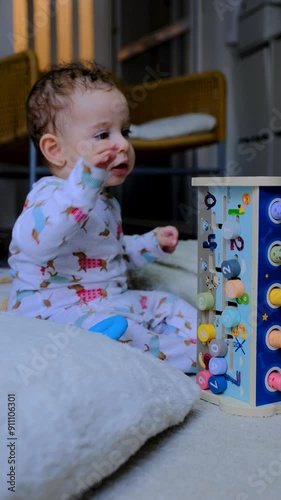 baby playing with wooden toy discovering it is angles and safely looking around it , plastic less toy