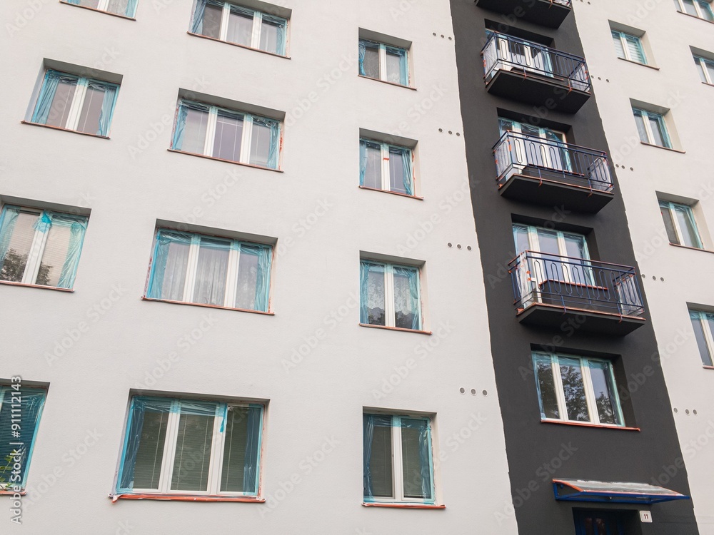 Obraz premium Reconstruction of facade on block of flats with blue cover protective foils
