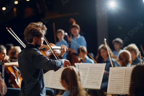 A man is playing the violin in front of a group of people. Concept of harmony and unity, as the group of musicians are all playing together in unison