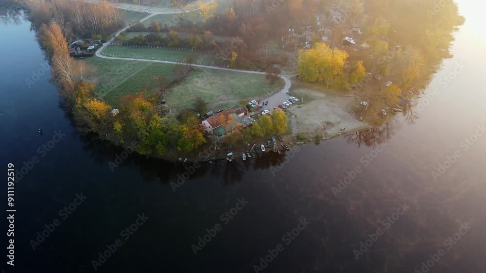 Drone view of old house surrounded with trees and rowboats stranded on lakeshore Drone view of old house surrounded with trees and rowboats stranded on lakeshore