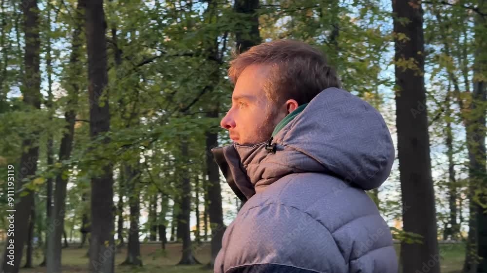 handsome young man walking in the park in autumn. Enjoying the weather, smiling, breathing fresh air handsome young man walking in the park in autumn. Enjoying the weather, smiling, breathing fresh air
