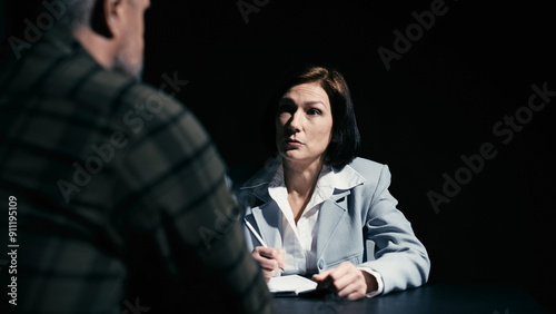 Canvas Print Female police detective questioning a male suspect in custody, interrogation roo