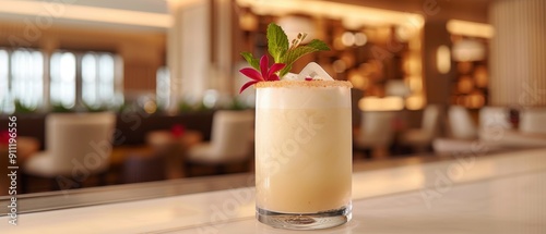 A refreshing tropical cocktail garnished with a flower and mint, served in a sophisticated bar setting.