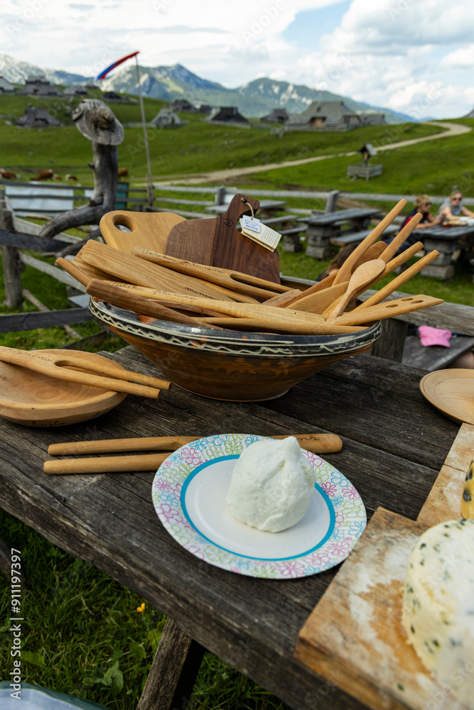 Fototapeta premium Velika Planina, Kamnik, Slovenia. Lord of the Rings style village. Wooden typical houses, hills, green meadows, flowers where cows and calfs graze. High quality artisanal milk and cheeses. Holiday.