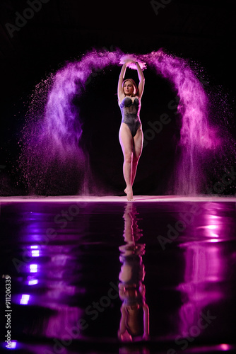 Obraz na płótnie Young slim woman posing near mirror surface with purple particles sprayed in the air w salonie
