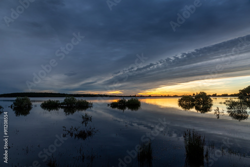 Vegetation and Valtabuyo Reservoir at dawn with cloudy sky, Tabuyo del Monte, León, Spain.